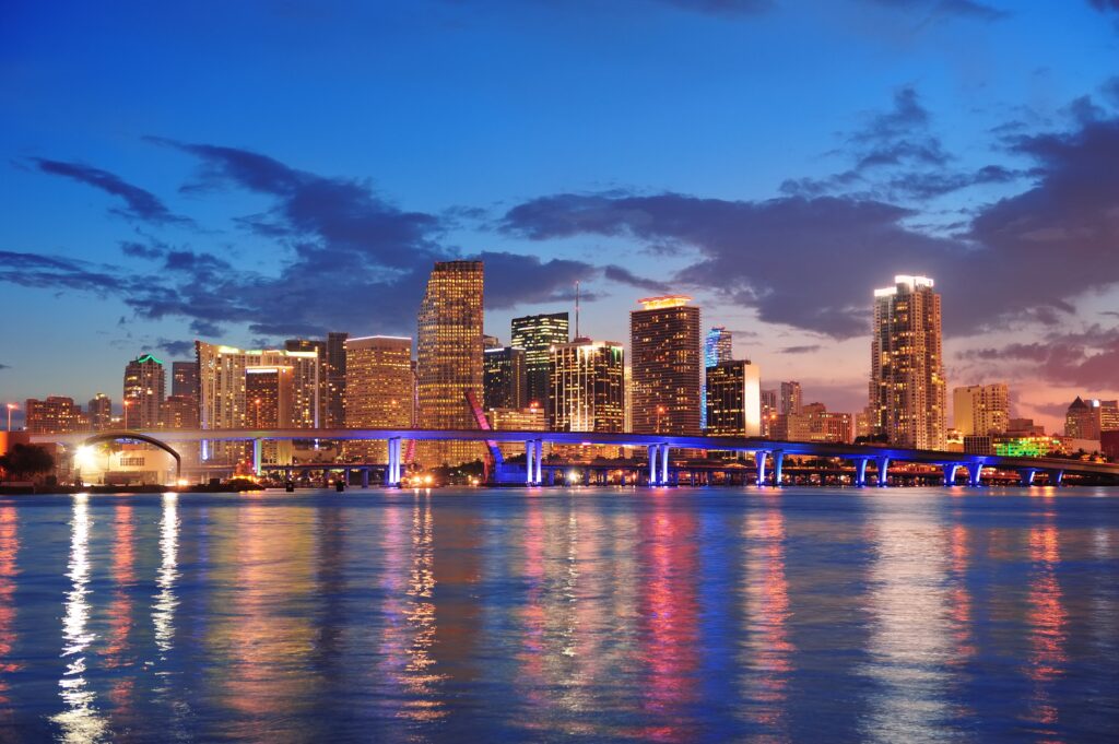Night view of downtown Miami with glowing city lights, symbolising professional and reliable auto transport services.